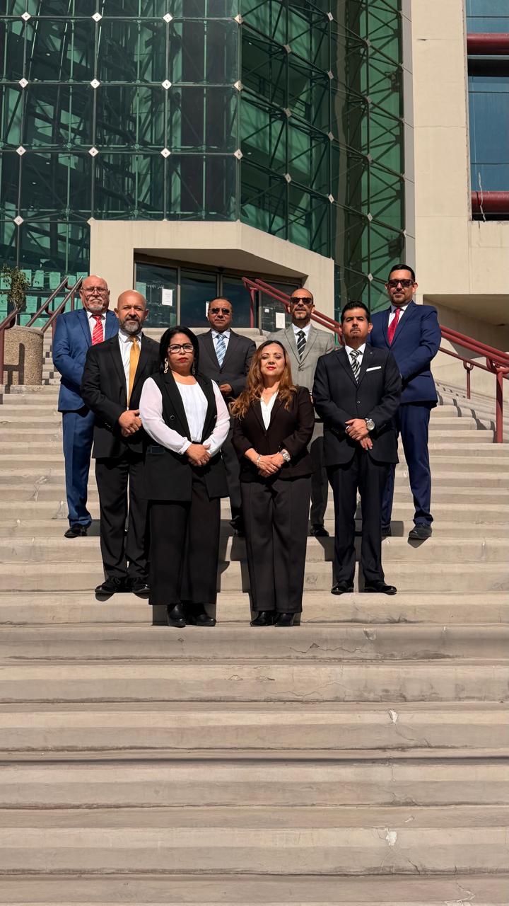 Fotografía del equipo en escalinatas de edificio institucional